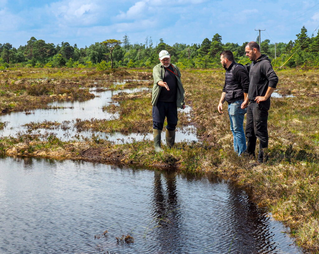 Photo of ecologist George Smith and the Gorman brothers discuss options for restoration measures on Clonneale More Bog