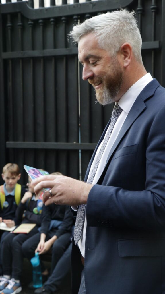 Photograph of Minister O’Sullivan looking at  the postcards from the Tyrrellspass children (Stephen Crilly - Tóchar Stories)