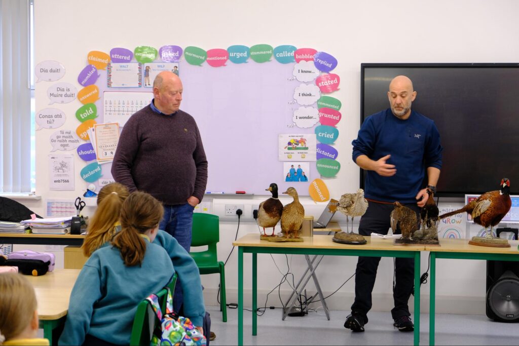 Photos sowing members of the local hunting club, Moore Game and Conservation Club, Pat and David, with their ‘dead zoo’ in the classroom -stuffed birds including ducks, curlew, pheasant and grouse.