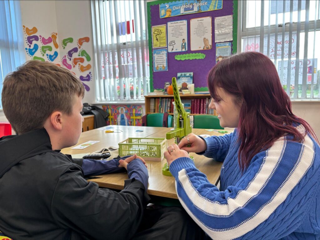 Photo of Artist, Sophie and student, Euan making badges 