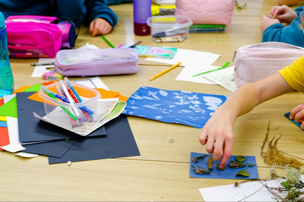 Photo of the children working on the collage assembly 
