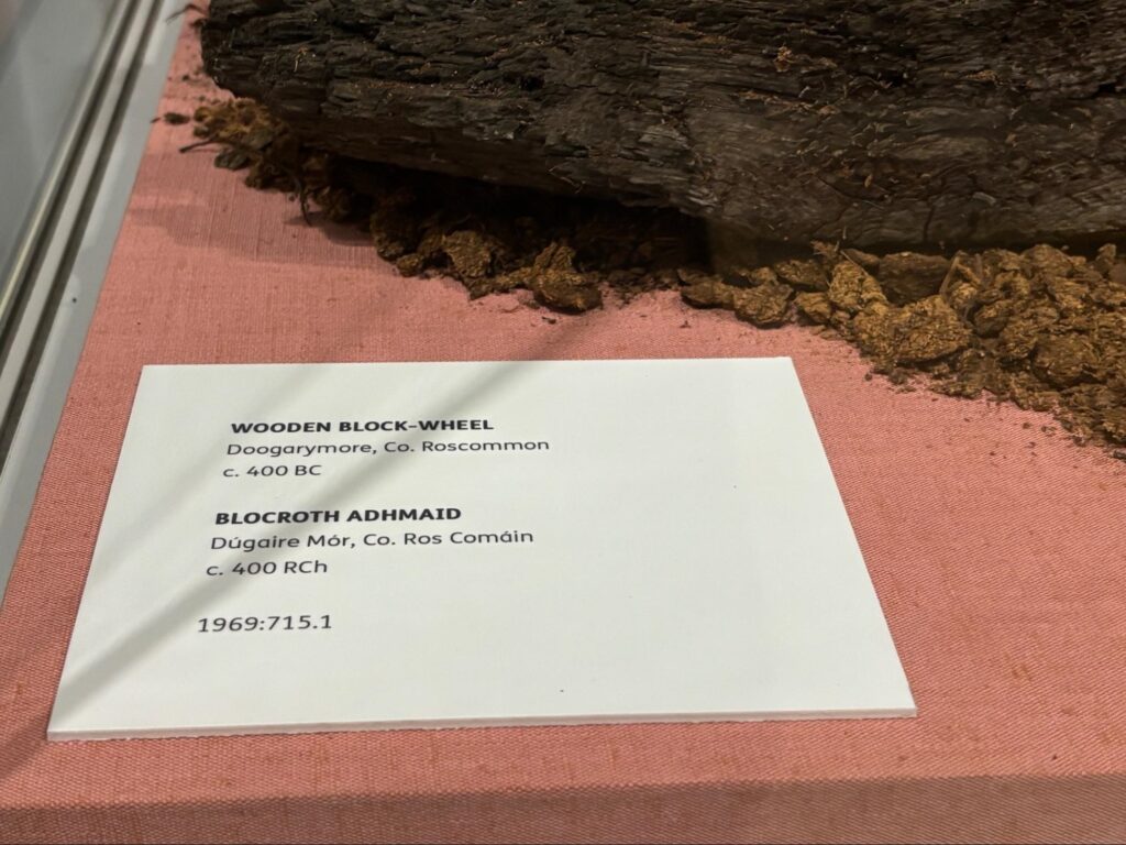 Photograph of the display label of the wooden block wheel found by the Mooney Brothers in 1969