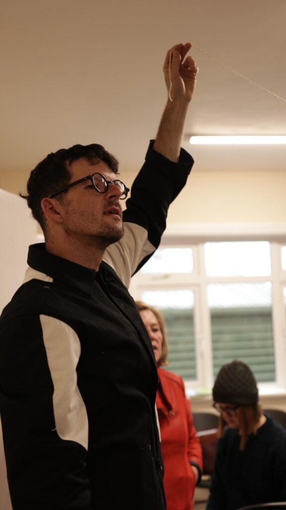 Luke Casserley with his hand raised holding the story thread