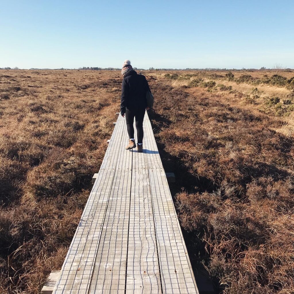 Photograph of Marie Gilmore walking on the boardwalk in Carrownagappul (credit Helen Shaw)
