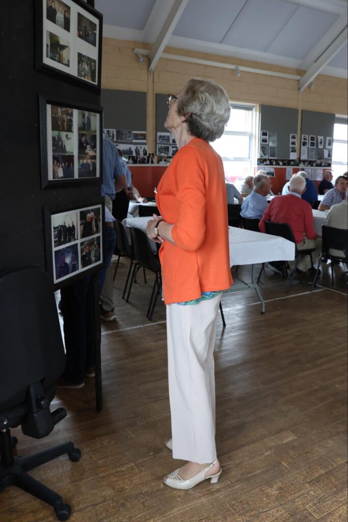 Photograph of Boora workers reunion - Mary Feighery studying the archive photos