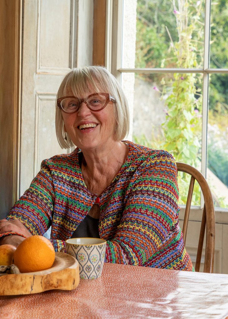 Woman sitting at kitchen table laughing and smiling