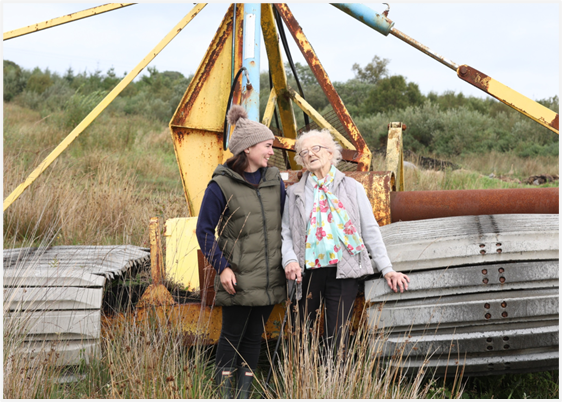 Shauna and her grandmother Elizabeth O’Neill at the abandoned turf machinery on the bog (Annie Holland)